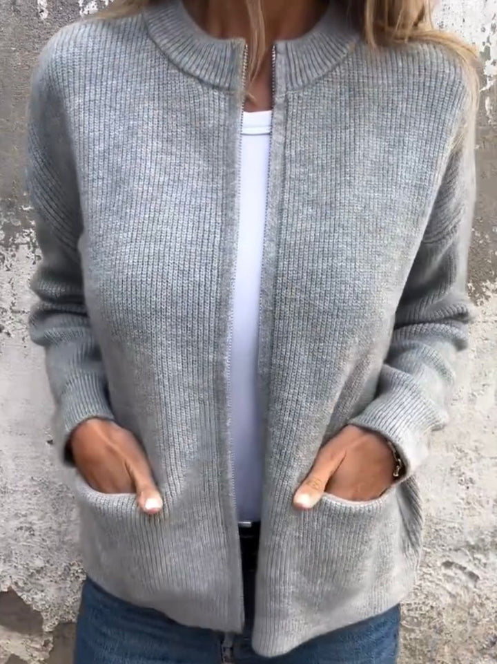 Elina graue Strick-Cardigan mit Reissverschluss, Vorderansicht mit Händen in den Taschen