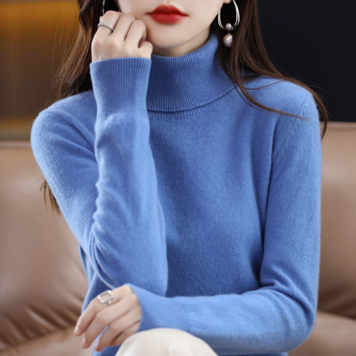 Frieda blauer Rollkragenpullover, Damen mit Hand am Kinn