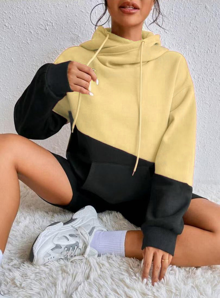 Meret Colorblock Hoodie mit Cowl-Neck in Aprikot-Schwarz, sitzend getragen
