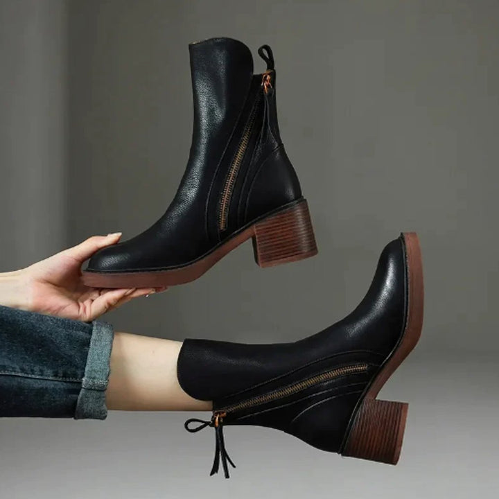Milena schwarze Ankle Boots hochgehalten und getragen