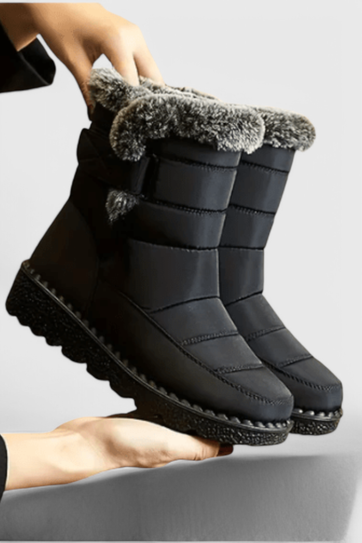 Nessa wasserdichte Winterstiefel in Schwarz mit Kunstfellbesatz, Seitenansicht in Händen gehalten