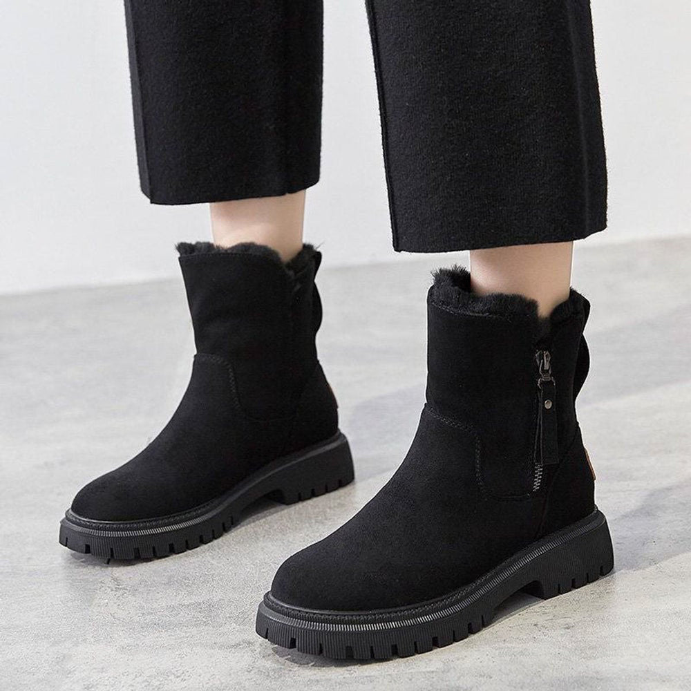 Romina Ankle Boots in Schwarz, an den Füssen getragen mit weiter Hose