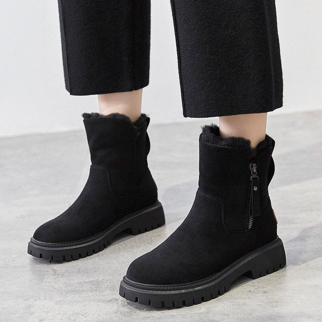 Romina Ankle Boots in Schwarz, an den Füssen getragen mit weiter Hose