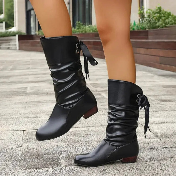 Schwarze Stiefel mit Blockabsatz, Rückansicht im Gehen