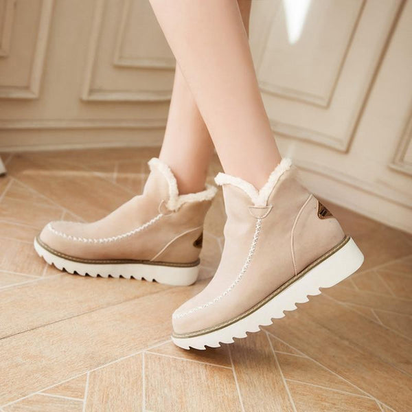 Selina Ankle Boots in Cognac, Rückansicht getragen auf blauem Teppich